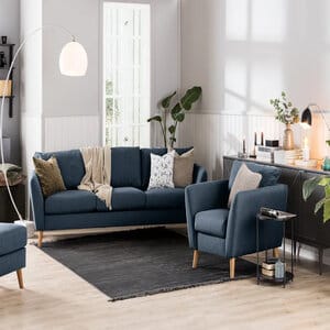 Trend 3-istuttava sininen kangassohva olohuoneessa, koristetyynyillä ja yhteensopivalla nojatuolilla sisustettuna
