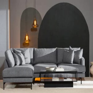 Menard L-muotoinen harmaa divaanisohva neljälle hengelle, modernissa olohuoneessa mustalla seinämaalauksella ja riippuvalaisimilla
