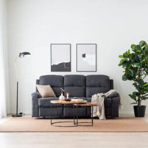 Savu 3-istuttava tummanharmaa mekanismisohva vaaleassa olohuoneessa, modernin sisustuksen keskellä