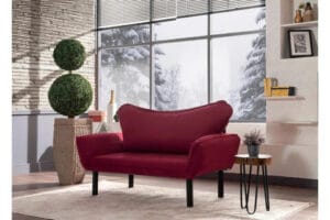 Punainen Vuodesohva Golda 2-istuttava valoisassa olohuoneessa, taustalla suuri ikkuna ja talvinen maisema