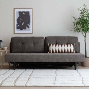 Ruskea Wilton 3-istuttava vuodesohva skandinaavisessa sisustuksessa, valkoisella matolla ja koriste-tyynyllä