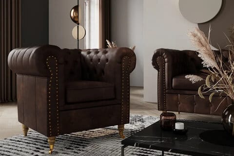 Tumma Chester Deluxe -nojatuoli Chesterfield-tyyliin, napitettu selkänoja, pyöristetyt käsinojat ja messinkiyksityiskohdat.