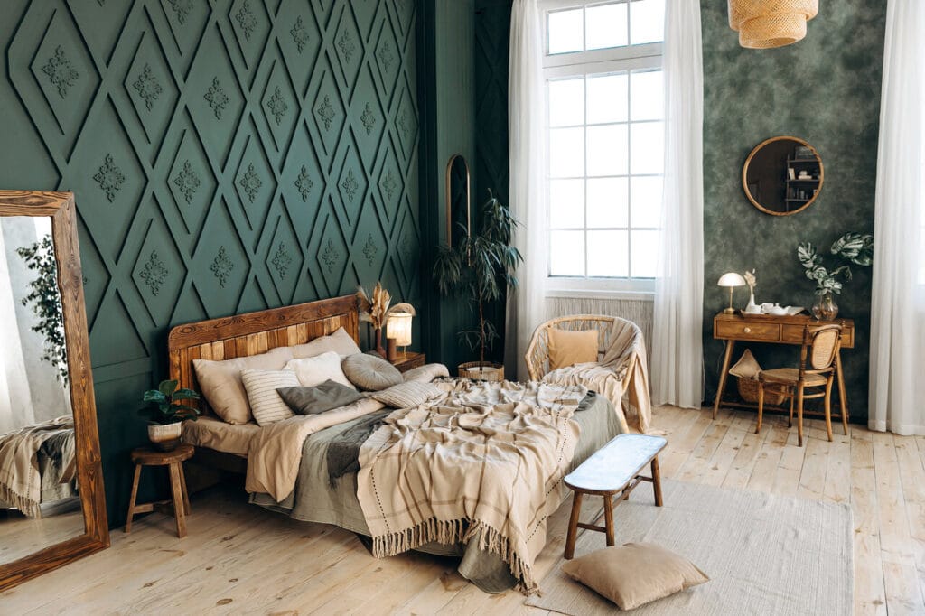 Boho-tyylinen makuuhuone tummanvihreillä seinillä, puukalusteilla ja luonnonmateriaaleilla sisustettuna