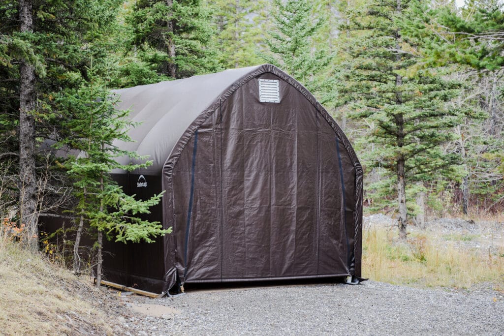 Ruskea pressukatos metsäisessä maisemassa sorapohjalla, ympärillä havupuita