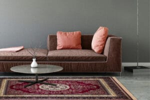 Punainen itämainen Casablanca Medallion -matto 200x300 cm ruskean sohvan ja pyöreän marmoripöydän kanssa harmaassa olohuoneessa