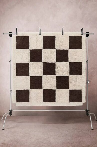 Jotex GANNAT -villamatto 250x250 cm, mustavalkoinen ruutukuvio ja paksu rakenne, ripustettuna telineeseen