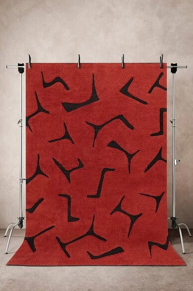 Punainen Jotex JUNIPER -villamatto, jossa mustia graafisia kuvioita, kokona 200x300 cm, esillä neutraalilla taustalla