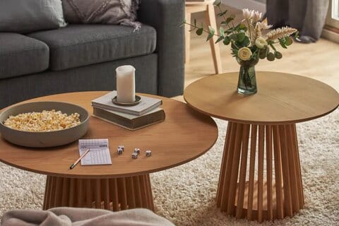 Kaksi Gontas-pöytää tammea olohuoneessa, toisessa kukkia ja toisessa popcornia ja kynttilä