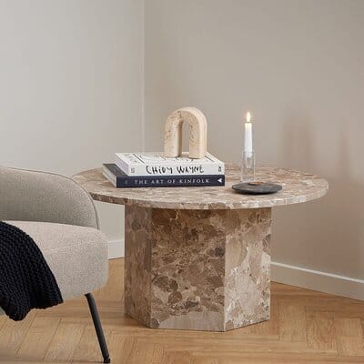 Pyöreä Naxos-sohvapöytä marmoria latte-sävyssä, kirjoja ja kynttilä pöydällä vaaleassa huoneessa
