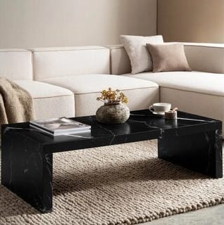 Suorakulmainen musta marmorisohvapöytä vaalean kulmasohvan edessä pehmeällä matolla