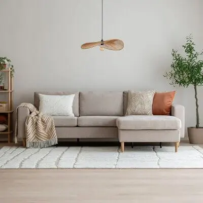 Vaalea beige divaanisohva modernissa olohuoneessa vaalean maton ja sisustustyynyjen kanssa.