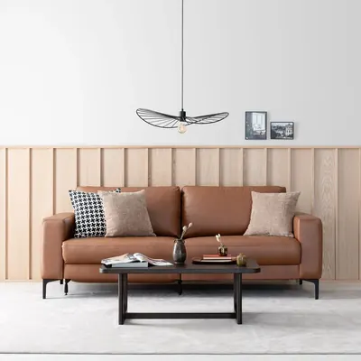 Konjakinruskea Hjort Studio 3-istuttava nahkasohva mekanismilla vaaleassa modernissa olohuoneessa.
